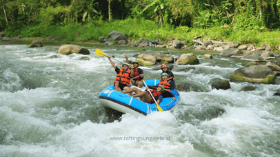 Perahu karet melintasi jeram deras dalam paket rafting ekstrem