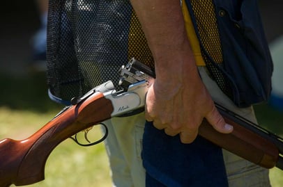 man holding an over under shotgun