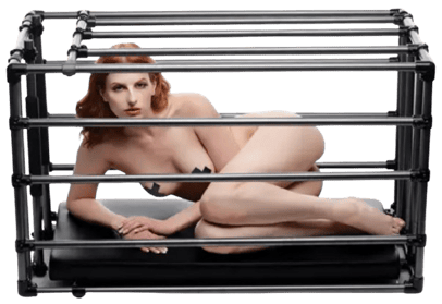 a woman in a fetish cage caged not wearing clothes but black tape over nipples 