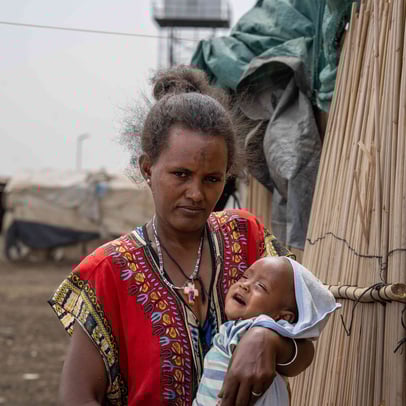 Mother holding her baby in a refugee camp in Sudan.