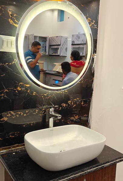 a bathroom sink with a mirror and a man in the mirror
