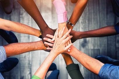 a group of people of different ethnical background holding hands together in a circle