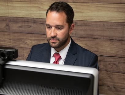 a man in a suit and tie is sitting at a desk