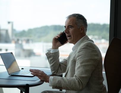 a man sitting at a table with a laptop and a laptop