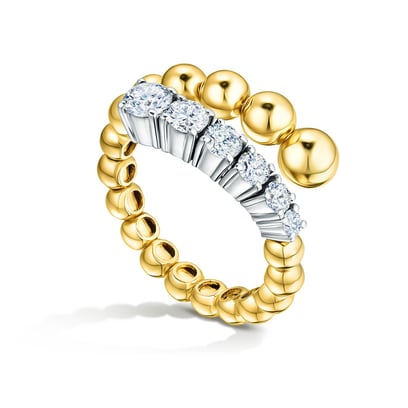 Gold ring with polished bead band and half-circle row of white diamonds in white metal prongs, on white background