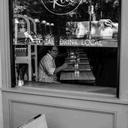 Man seen through window of coffee shop.