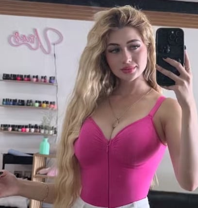 a woman in a pink top and white pants