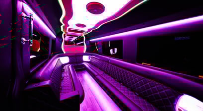 The inside of a party bus limo with pink neon