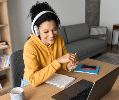 Young woman attending online speech therapy session, wearing headphones and smiling at her therapist