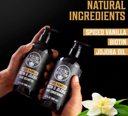 two hands holding two bottles of vanilla shampoo and conditioner