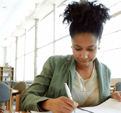 A woman writing on her free Revive after 40 Perimenopause Survival Checklist