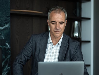 a man in a suit and tie is sitting at a desk