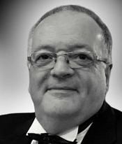 a man in a suit and bow tie holding a wine glass