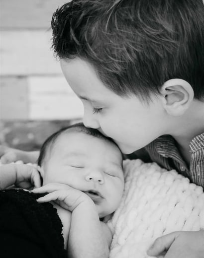 rand frère embrassant bébé sur le front – photo noir et blanc, naissance Gard