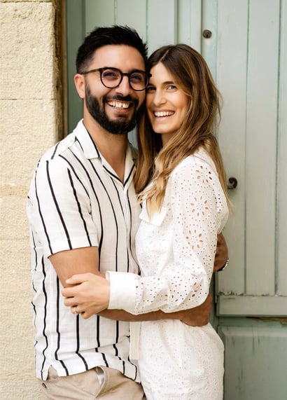 Smiling couple in front of an old door — fine art portrait in a Provençal village