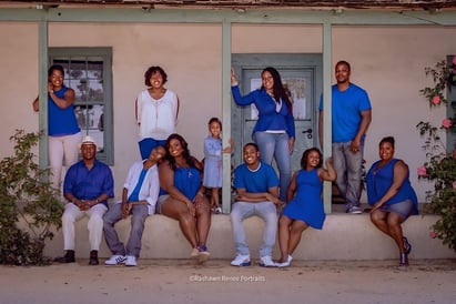 a family posing for a photo in front of a house