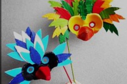 a person holding a paper flower with a bird on it
