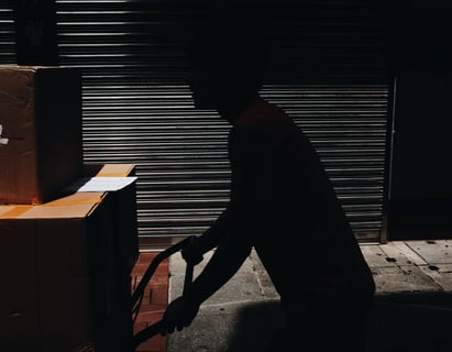 a man in a black shirt is moving boxes