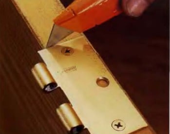 a person using a knife to cut a piece of wood