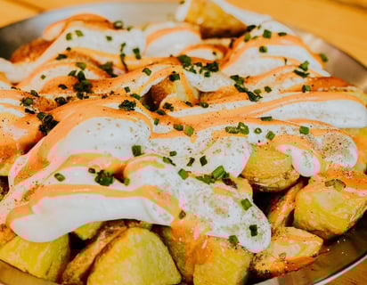 Ración de patatas bravas caseras con salsa brava y alioli del restaurante Santa Lola