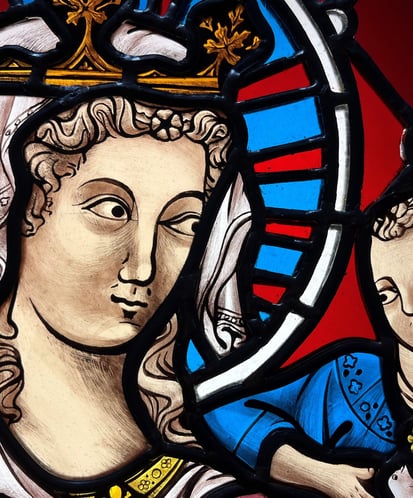 a stained glass window with a painting of a woman