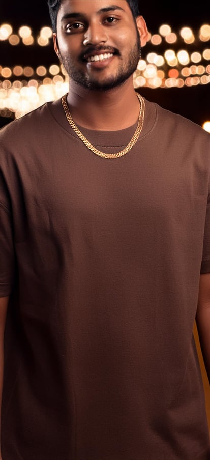 a man in a brown oversized t-shirt and a chain link necklace