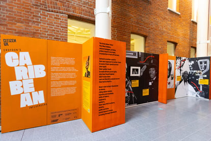 a museum exhibition display of images and text on orange background