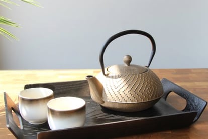 a teapot with teapots and cups on a tray