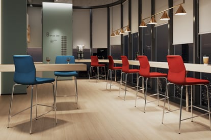 Bar-height blue and red Rita chairs in a modern office lounge with city night view