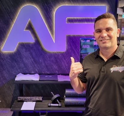 Kahn from SweetAz Co. in front of the Anytime Fitness sign at the Chermside gym during their grand opening event.