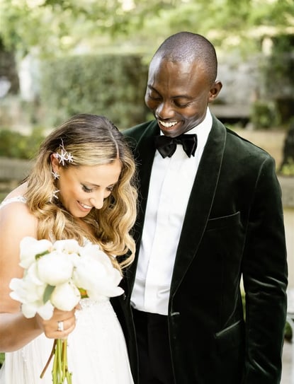 Groom walking around bride to admire her wedding dress during their first look