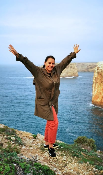 a woman standing on a cliff overlooking the ocean