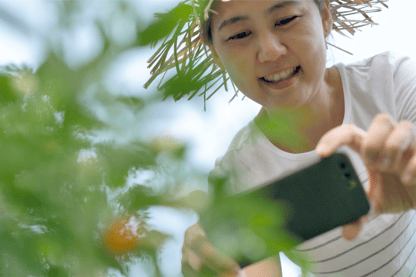 Woman taking photos of her plants to share with Pluck for help