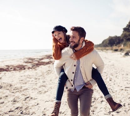 Una pareja feliz corriendo por la playa