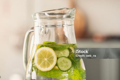 a pitcher of water with slices of cucumber in a pitcher