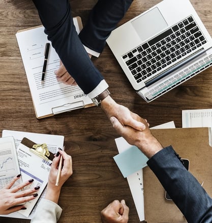 a group of people shaking hands over papers