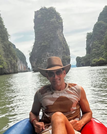 Travel writer Rick Silvia kayaks in Kong Bay with gigantic limestones in the background