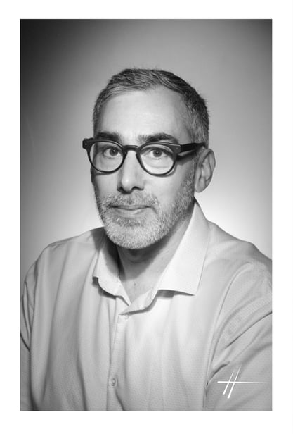 a man with glasses and a white shirt