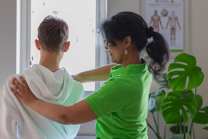 a woman in a green shirt is turning a person