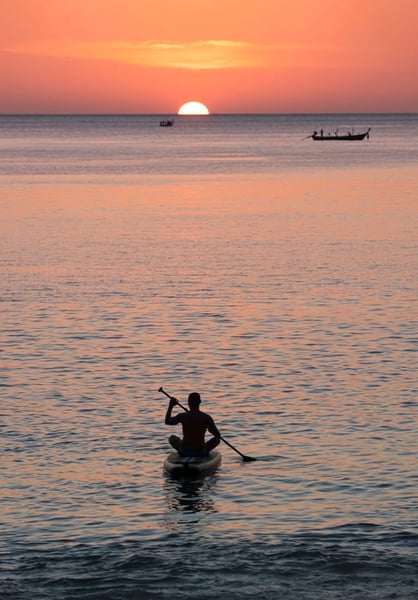Travel writer Rick Silvia paddles into the sunset by kayak in the bay of Bang Tao