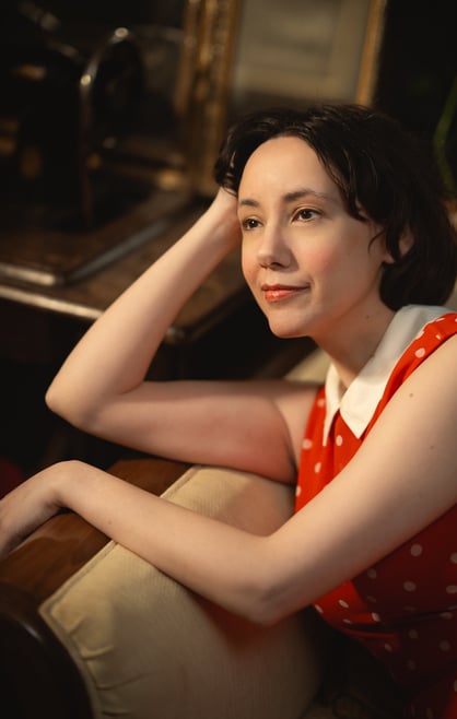 Maria in a read polkadot dress looking ahead
