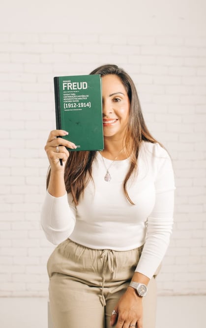 Fátima com um livro de Freud em frente a metade do rosto