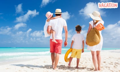 a family of four standing on a beach