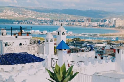 Vue panoramique de Tanger, Maroc, montrant la médina historique aux bâtiments blancs et le port animé, reflétant la fusion de