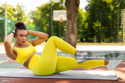 a woman doing a cruncher on a basketball court