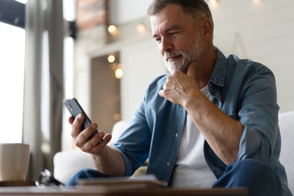 En man läser på en smartphone
