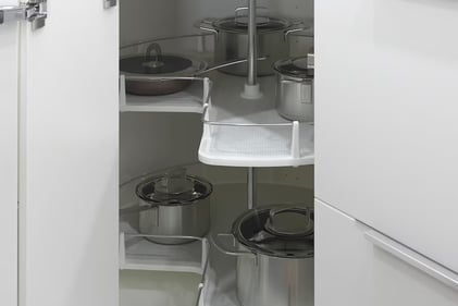 a kitchen with a white cabinet and potsted pots