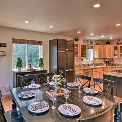 Spacious dining area adjacent to a fully equipped kitchen with forest views at Moose Creek Lodge.