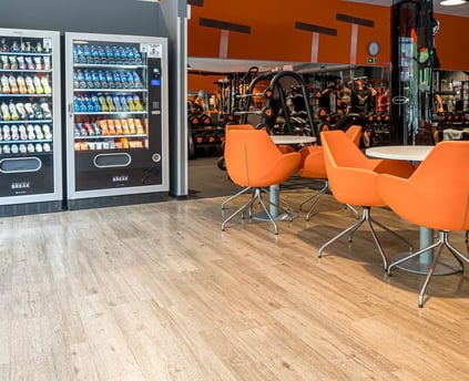 a restaurant with orange chairs and a vending machine