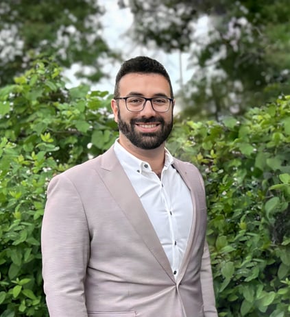 a man in a suit and glasses smiling